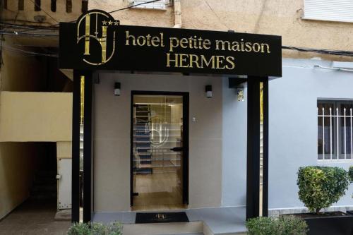 a hotel petite revision therapies sign in front of a building at Hermes Petite Maison Hotel in Tirana