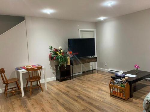 a living room with a television and a table and chairs at A Cozy 2 beds Suite in Whistle Bend in Whitehorse