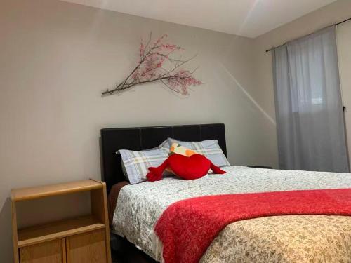 a bedroom with a bed with a red stuffed animal on it at A Cozy 2 beds Suite in Whistle Bend in Whitehorse