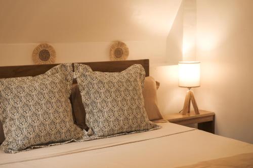 a bedroom with a bed with a pillow and a lamp at Pahinga Villas Siargao in Libertad
