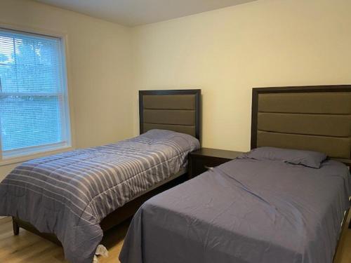 ワーウィックにあるWarwick Rentalのベッド2台と窓のある寝室