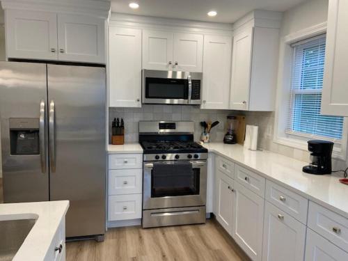 ワーウィックにあるWarwick Rentalのキッチン(ステンレス製の電化製品、白いキャビネット付)