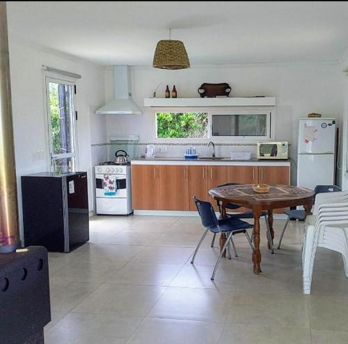 een keuken met een tafel, stoelen en een koelkast bij Petrel in La Paloma
