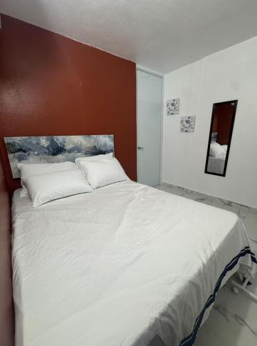 a bedroom with a large bed with white sheets at Hospedaje paz y amor in San Juan