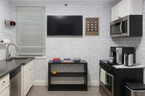 a kitchen with black appliances and a tv on the wall at Lavender style Room in New York