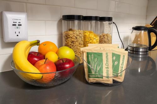 a counter with a bowl of fruit and a jar of cereal at Lemon Vibes room in New York