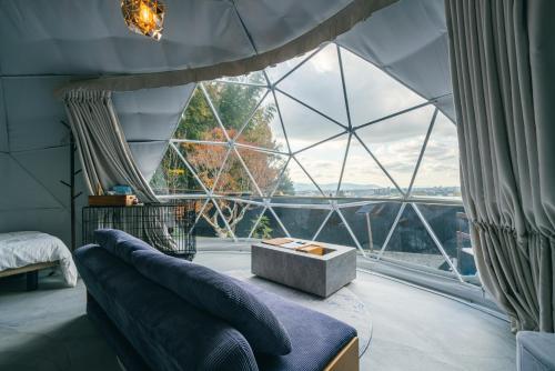 a room with a couch and a large window at private your resort ITTEKURAi 松山 in Kawakami