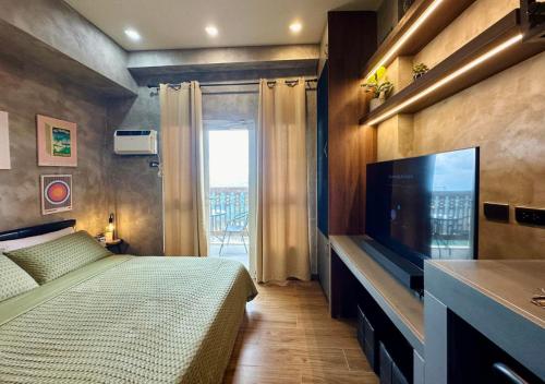 une chambre avec un lit et une télévision à écran plat dans l'établissement Studio in Twin Lakes Tagaytay, à Laurel