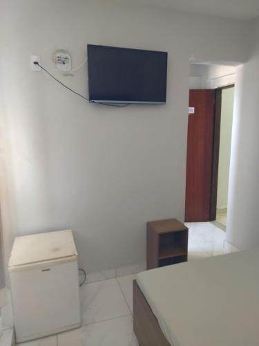 Zimmer mit einem Bett und einem TV an der Wand in der Unterkunft Hotel Gold - Brasília in Brasilia