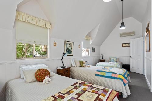 Ein Schlafzimmer mit zwei Betten und einem Stofftier auf einem Kissen in der Unterkunft Glenrose Cottages in Warwick