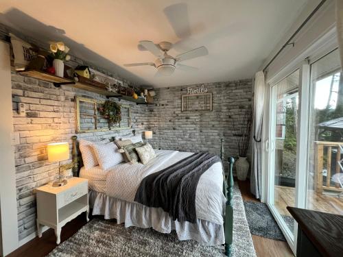 Schlafzimmer mit Ziegelwand und Bett in der Unterkunft Mile 77 Cottages in Youbou