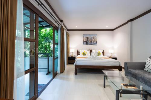 a bedroom with a bed and a couch at Bang Po Hut in Ban Bang Po