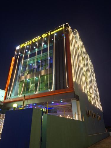 DhangadhiHotel Dev Inn的一座大建筑,上面有灯,晚上