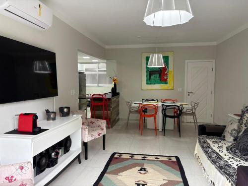 a living room with a couch and a table at Apartamento completo, 200mts da praia de Pitangueiras in Guarujá
