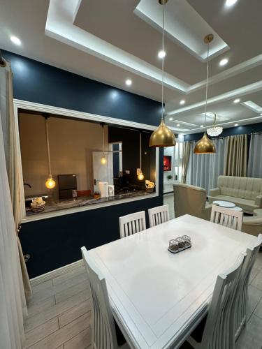 a dining room with a white table and chairs at Luxury home in Entebbe