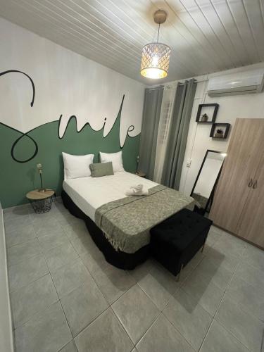 une chambre avec un lit et un mur vert dans l'établissement L'ikonik, à Cayenne