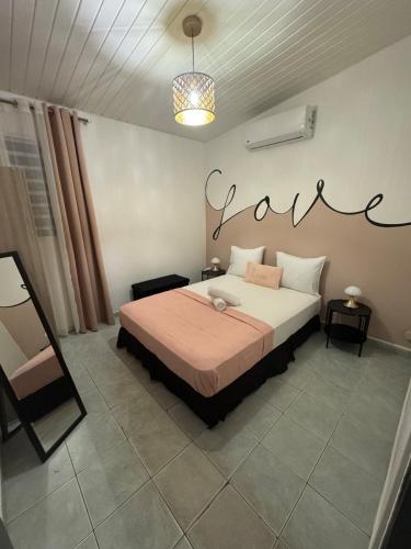 une chambre avec un lit et une pancarte au mur dans l'établissement L'ikonik, à Cayenne