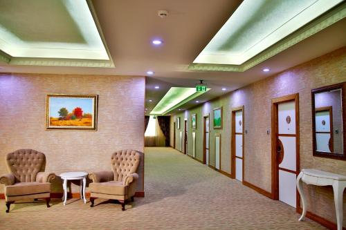 a hallway of a hospital with two chairs and tables at Graaf Hotel in Baku