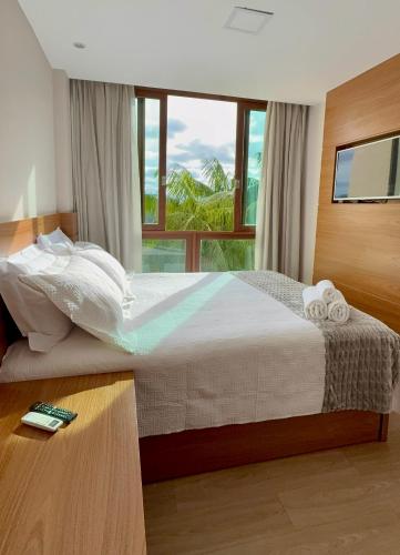 a bedroom with a bed with a large window at Apartamento quarto e sala, varanda com vista para a Pedra Azul e cozinha completa no Condomínio Vista Azul in Pedra Azul