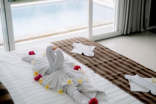 a white swan decoration on a bed in a room at Casa Verona in Lovina
