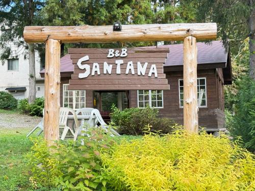 a sign for a santana restaurant in a yard at Santana Lodge Hakuba in Hakuba