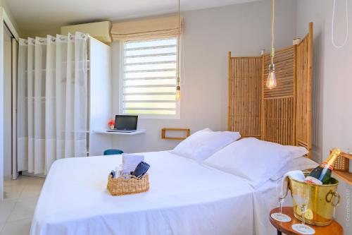 a bedroom with a white bed with a basket on it at A L'Arche Bleue in Le Robert