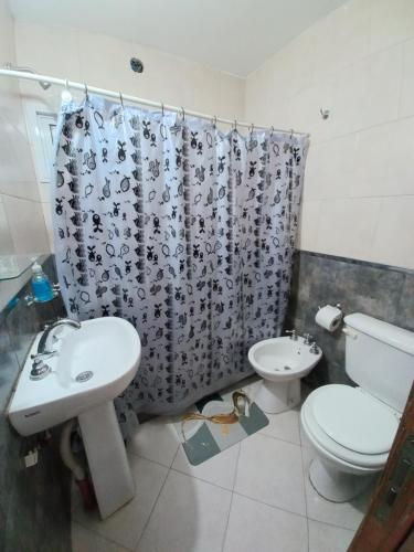 a bathroom with a sink and a toilet and a shower curtain at Tierra Mia II in Carpintería