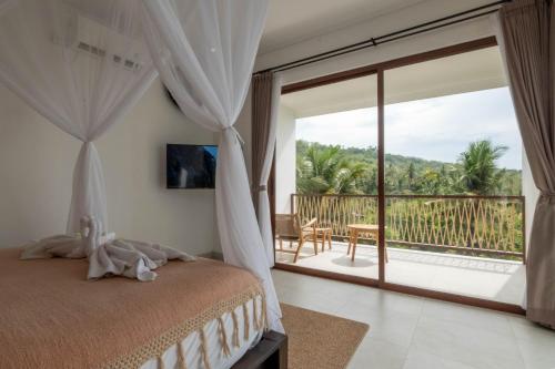 een slaapkamer met een bed en een balkon met uitzicht bij Grand Abinawahill in Lovina