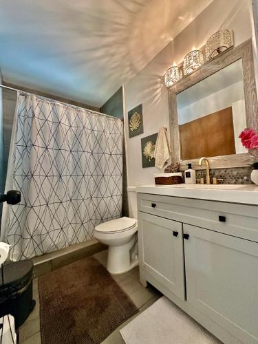 a bathroom with a toilet and a sink and a mirror at Beach and Downtown Hollywood in Hollywood