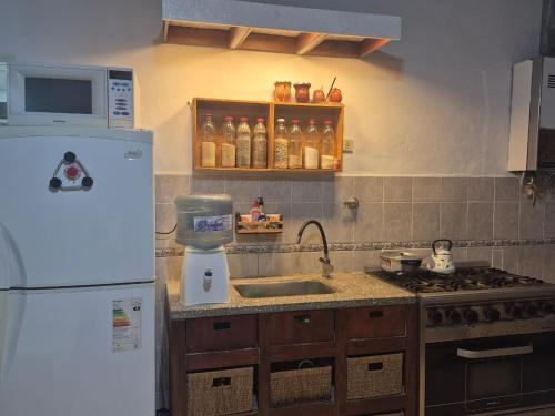 eine Küche mit einem weißen Kühlschrank und einer Spüle in der Unterkunft Casa en Pueblo Esther in Pueblo Esther