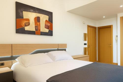 Un dormitorio con una cama y un cuadro en la pared. en PUERTA DEL SOL - Vigo Centro, en Vigo