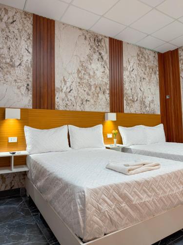 two beds in a hotel room with two bedsvisor at Hotel baramar moca in Moca