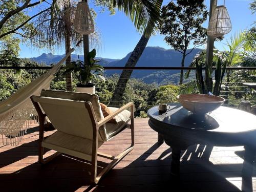 a patio with a table and a chair and a table at Heaven's Gate in Currumbin Valley