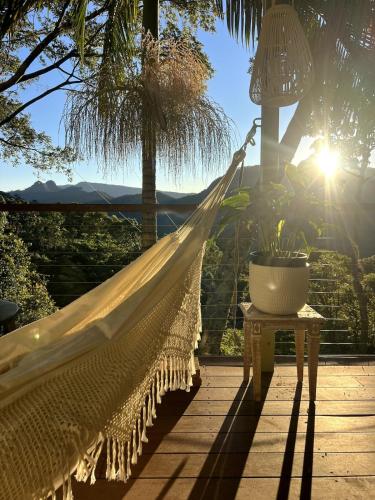a hammock on a porch with a view of the mountains at Heaven's Gate in Currumbin Valley