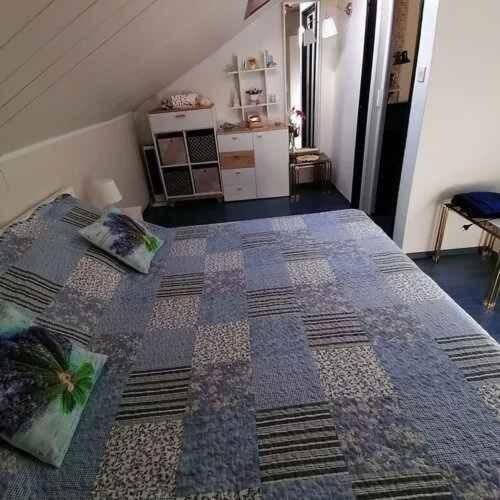 an attic room with a bed with pillows on it at Apartment in Crikvenica 53539 in Sopaljska