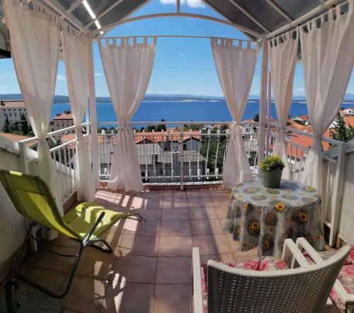 a balcony with a table and chairs and a view of the ocean at Apartment in Crikvenica 53539 in Sopaljska