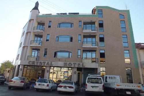 a hotel with cars parked in front of it at Crystal Hotel in Asmara