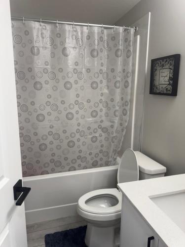 een badkamer met toilet en douchegordijn bij Modern 2-bed 1-bath Suite in Calgary