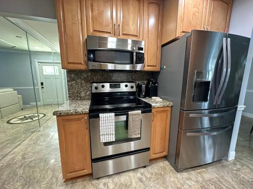 a kitchen with stainless steel appliances and wooden cabinets at BLD Vacation Residences in West Palm Beach