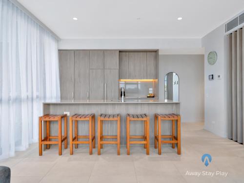 cocina con taburetes de madera y nevera en CODA 410, en Coffs Harbour