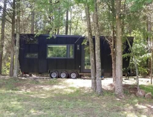 een zwart tiny house in het bos bij Stylish Tiny House for Glamping in South Carolina in Rock Hill