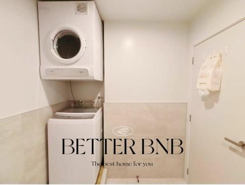 een wasmachine en droger in een badkamer met een wasmachine bij Free Parking AC Cooling and CBD View in Wellington
