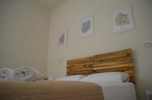 a bedroom with two beds and a wooden headboard at B&B La Via di Casa in San Leone