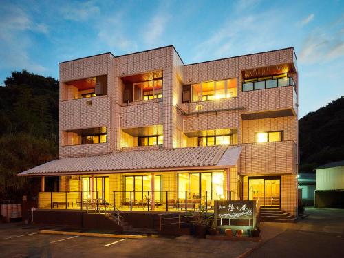 a tall building with lights on in a parking lot at 真砂悠々庵 in Minamichita