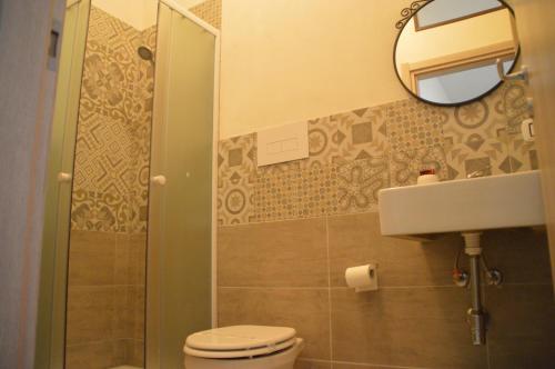 a bathroom with a toilet and a sink and a mirror at B&B La Via di Casa in San Leone
