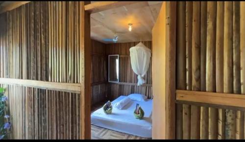 a room with two beds in a room with wooden walls at Rumsram Homestay by Rumah Etnik Papua Sorong in Papermaranda