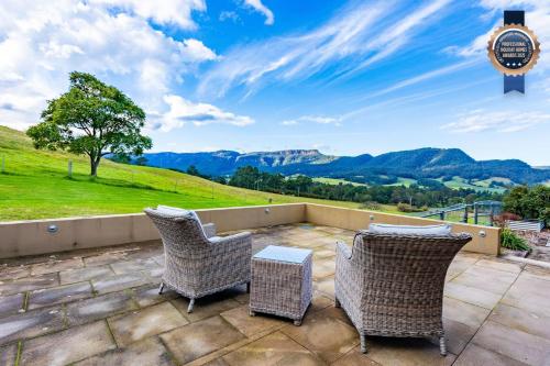 a patio with chairs and a view of mountains at The Dairy at Cavan I Kangaroo Valley I Stunning Views in Barrengarry