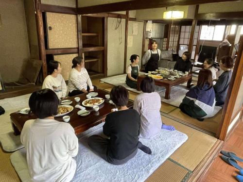 a group of people sitting around a table in a room at Hygge KAWATABI in Osaki