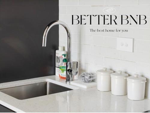 a kitchen sink with a faucet and three white containers at CBD Gem Cooling Summer and City View in Wellington