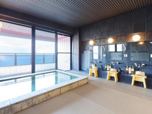 a large bathroom with a swimming pool with two sinks at 真砂悠々庵 in Minamichita